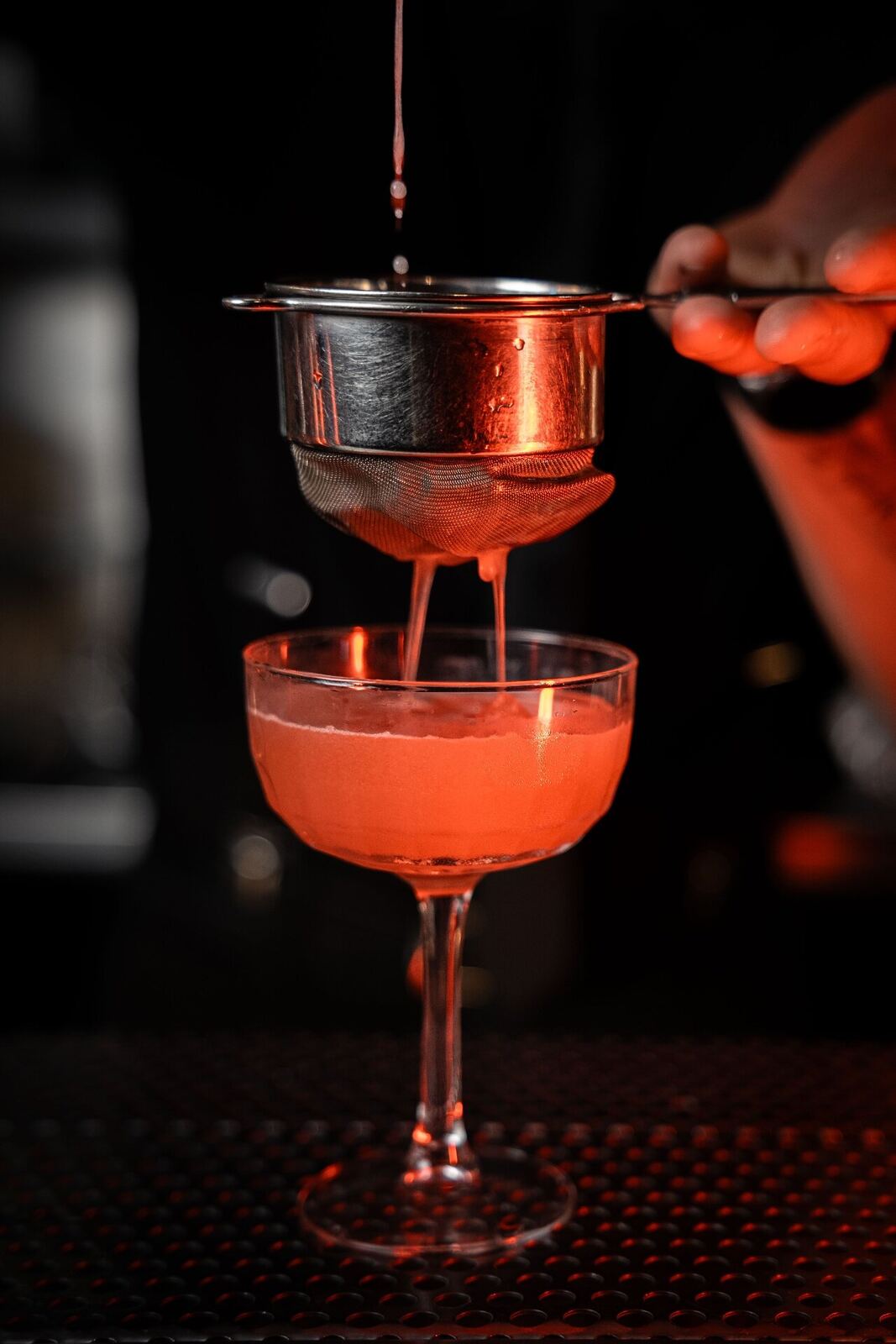Colata di un cocktail in luce rossa